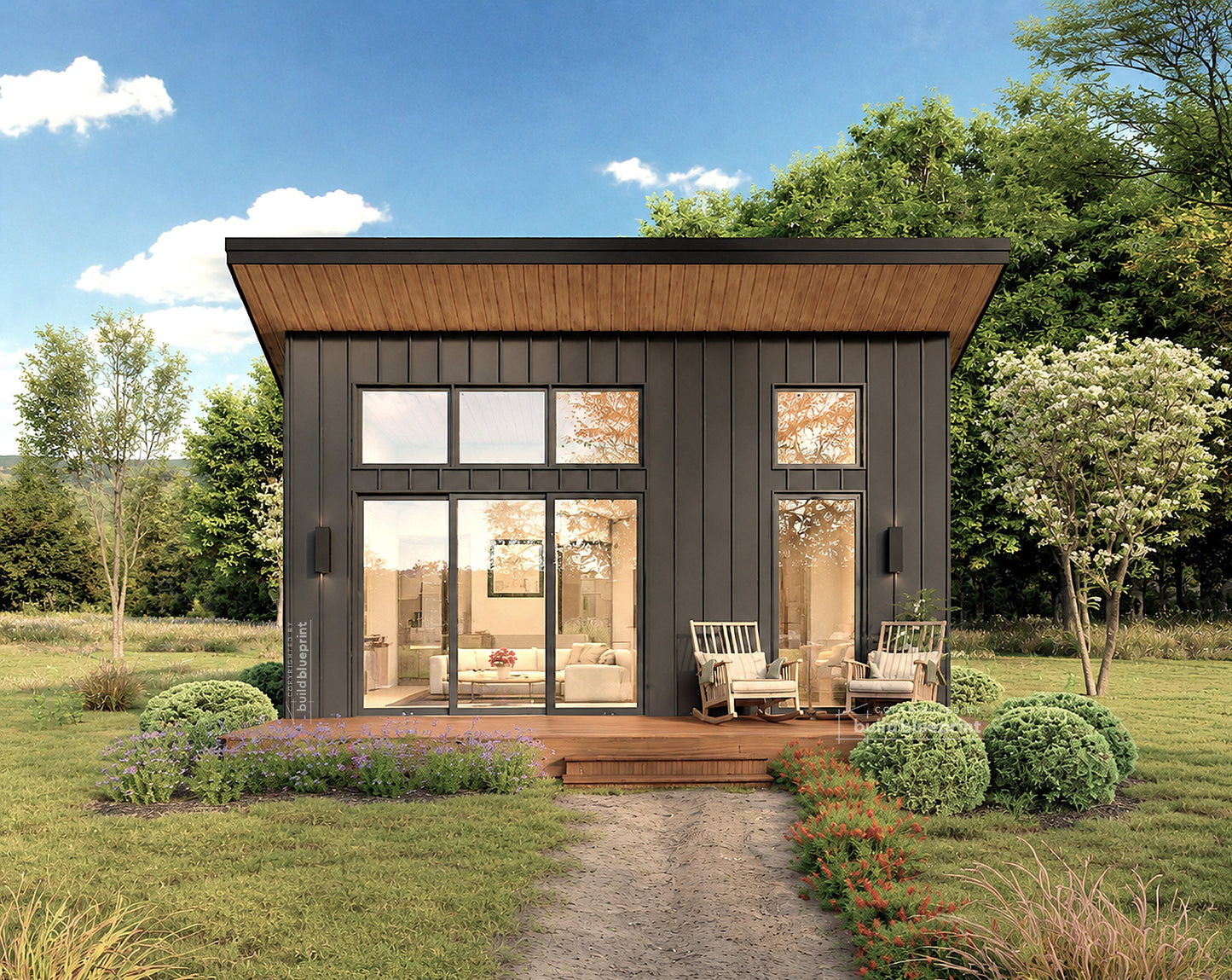 A modern single-story cabin with dark charcoal gray siding, large floor-to-ceiling glass windows, and a wood-look roof over a wooden deck, shown in a landscaped yard with trees and a blue sky.