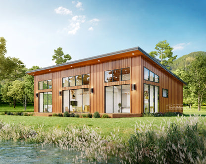 A modern single-story cabin with dark charcoal metal siding, large floor-to-ceiling windows, and a wooden roof trim, situated on a grassy bank next to a clear stream under a blue sky with trees in the background.
